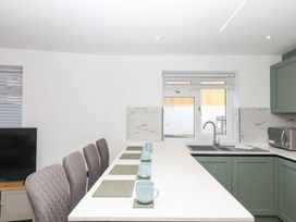 A kitchen with a sink and chairs at Greenswood Mews in Brixham