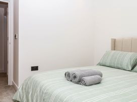A bedroom with a bed and towels at Greenswood Mews in Brixham