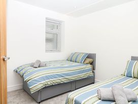 A bedroom with two beds and towels at Greenswood Mews in Brixham
