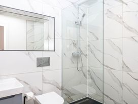 A bathroom featuring a shower, toilet, and sink at Greenswood Mews in Brixham