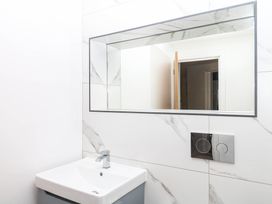 A bathroom with a sink and mirror at Greenswood Mews in Brixham