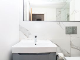 A bathroom with a sink and mirror at Greenswood Mews in Brixham