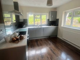 A kitchen with modern appliances and a view of the garden at Saddleback Bungalow in Llandrindod Wells