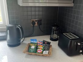 A kitchen counter with kettle, toaster, coffee, and tea bags at Saddleback Bungalow in Llandrindod Wells