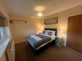 A bedroom with double bed and lamps at Saddleback Bungalow Llandrindod Wells