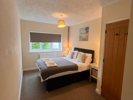 A bedroom with a bed and window at Saddleback Bungalow in Llandrindod Wells
