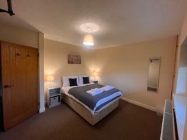 A bedroom with a bed and bedside table at Saddleback Bungalow in Llandrindod Wells