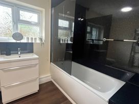 A bathroom with a bathtub and sink at Saddleback Bungalow Llandrindod Wells