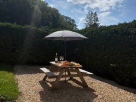 A garden with a table under an umbrella at Saddleback Bungalow Llandrindod Wells