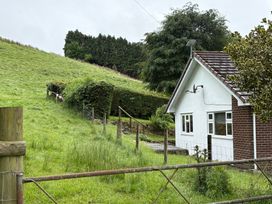 A house with a fence and grass in a rural area at Saddleback Bungalow Llandrindod Wells