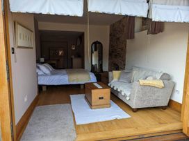 A living room with a bed and sofa at The Old Chapel of Ermington Converted Vestry in Ermington