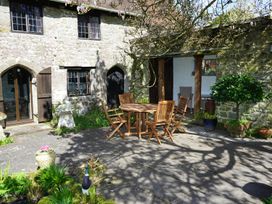 An outdoor area with a table and chairs near a stone wall at The Old Barn in Manchester