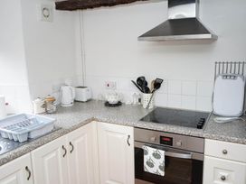 A kitchen with a stove, oven, kettle, dish rack and utensils at The Old Barn in Manchester