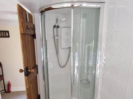 A shower with a door and controls at the bathroom