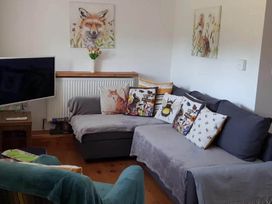 A living room with a sofa and television at 3 Bedroom Cottage Hot Tub Garden Parking Dunkeswell