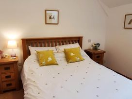 A bedroom with a bed and bedside table at 3 Bedroom Cottage Hot Tub Garden Parking Dunkeswell