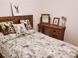 A bedroom with a bed and wooden furniture at 3 Bedroom Cottage Hot Tub Garden Parking Dunkeswell