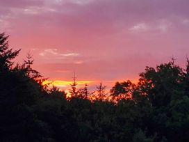 A sunset view with trees at 3 Bedroom Cottage Hot Tub Garden Parking Dunkeswell