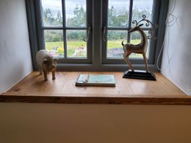 A window sill with a pig figurine, a deer figurine, and a notebook at 3 Bedroom Cottage Hot Tub Garden Parking Dunkeswell