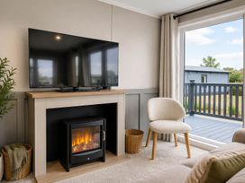 A living room with a television and fireplace at Lovely Holiday Home On Waxham Sands Great Yarmouth