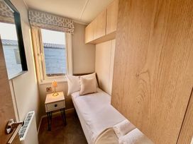 A bedroom with a single bed and lamp at Lovely Holiday Home On Waxham Sands in Great Yarmouth