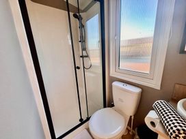 A bathroom with a shower and toilet at Lovely Holiday Home On Waxham Sands in Great Yarmouth