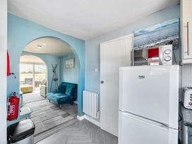 A kitchen with a fridge, microwave, and armchair at the property