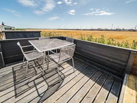 An outdoor patio with a table and chairs in a field at 