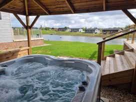 A hot tub with a view of a lake at Pet Friendly 2Bed Luxury Lodge in Routh HotTub Heron Lakes Luxury Lodge Park near Beverley