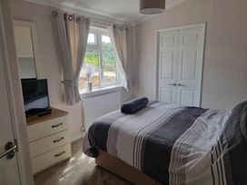 A bedroom with a bed and television at Pet Friendly 2Bed Luxury Lodge in Routh HotTub Heron Lakes Luxury Lodge Park near Beverley