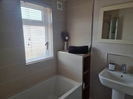 A bathroom with a bathtub and hand basin at Pet Friendly 2Bed Luxury Lodge in Routh HotTub Heron Lakes Luxury Lodge Park near Beverley