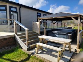 An outdoor area with a hot tub and picnic table at Pet Friendly 2Bed Luxury Lodge in Routh HotTub Heron Lakes Luxury Lodge Park near Beverley