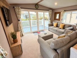 A living room with a sofa and television at Vintage 121 Southview Holiday Park Skegness