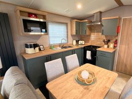 A kitchen with a sink, stove, and microwave at Vintage 121 Southview Holiday Park Skegness