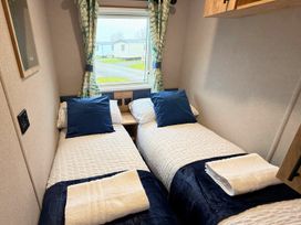 A bedroom with two single beds and window at Vintage 121 Southview Holiday Park Skegness