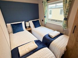 A bedroom with two single beds and a window at Vintage 121 Southview Holiday Park Skegness