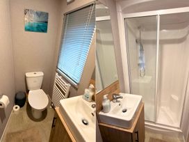 A bathroom with a toilet, sink, and shower at Vintage 121 Southview Holiday Park Skegness