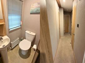 A bathroom featuring a toilet, sink, and radiator at Vintage 121 Southview Holiday Park Skegness