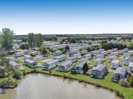 A view of mobile homes around a lake at Vintage 121 Southview Holiday Park Skegness