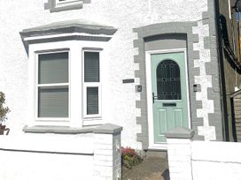 A house with a green door and windows at 4 Bed House Sleeps 8 Garden Pets Near Beach in Llandudno