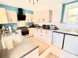 A kitchen with countertop, sink, oven, and appliances at 4 Bed House Sleeps 8 Garden Pets Near Beach Llandudno