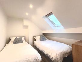 A bedroom with two beds and a skylight at 4 Bed House Sleeps 8 Garden Pets Near Beach Llandudno