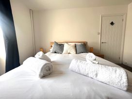 A bedroom with a bed and towels at 4 Bed House Sleeps 8 Garden Pets Near Beach in Llandudno