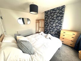 A bedroom with a bed, mirror, wardrobe, and dresser at 4 Bed House Sleeps 8 Garden Pets Near Beach Llandudno