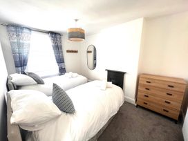 A bedroom with two beds and a mirror at 4 Bed House Sleeps 8 Garden Pets Near Beach Llandudno