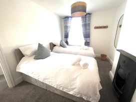 A bedroom with two beds and a window at 4 Bed House Sleeps 8 Garden Pets Near Beach Llandudno