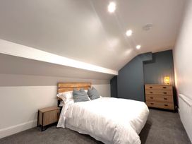 A bedroom with a bed and nightstand at 4 Bed House Sleeps 8 Garden Pets Near Beach Llandudno