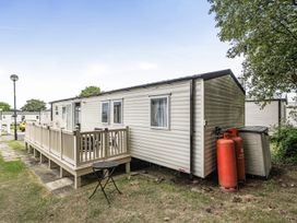 An outdoor view of a caravan with decking and gas cylinders at Primrose Valley 3Bed Caravan Sleeps 8 Pets Ok, Primrose Valley
