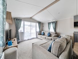 A living room with a television and two sofas at Primrose Valley 3Bed Caravan Sleeps 8 Pets Ok in Primrose Valley