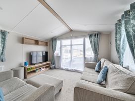 A living room with a sofa and television at Primrose Valley 3Bed Caravan Sleeps 8 Pets Ok in Primrose Valley